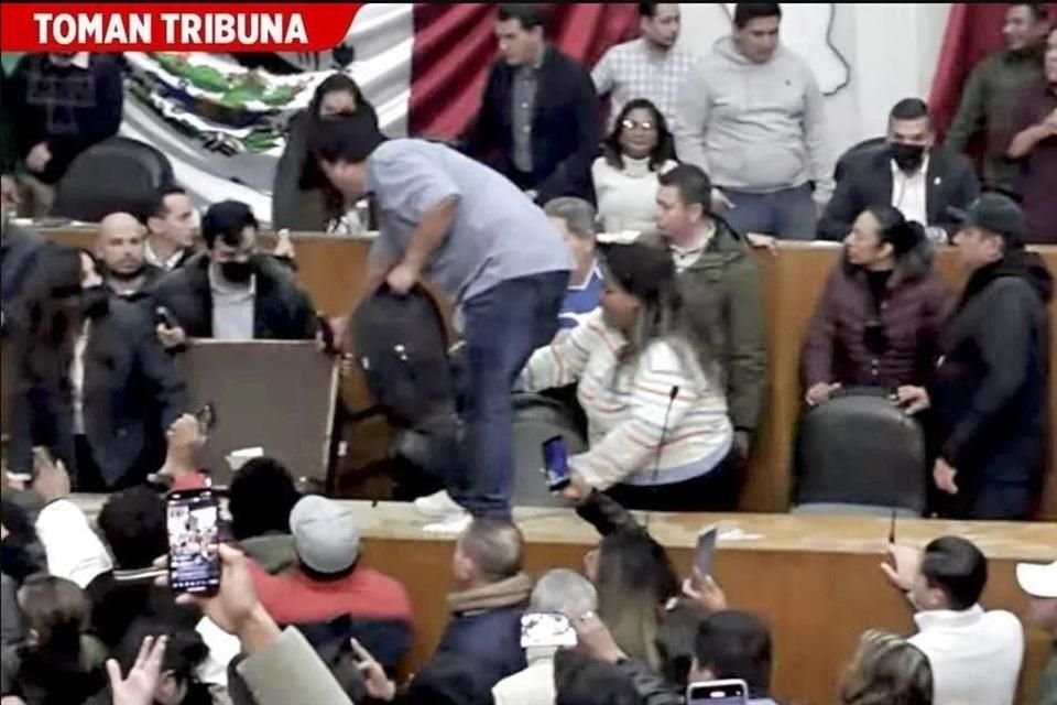 Cuando empezó la lectura del dictamen, una turba de emecistas, encabezados por líderes de ese partido, irrumpió en el recinto, buscaron impedir que la sesión siguiera.