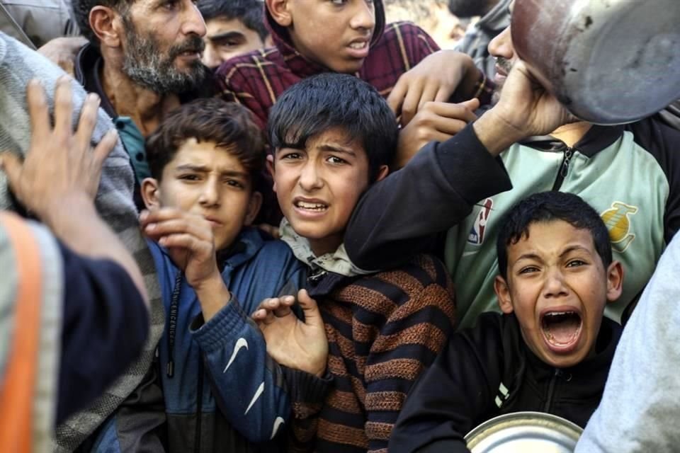 Palestinos hacen cola para recibir comida en Rafah, Franja de Gaza.