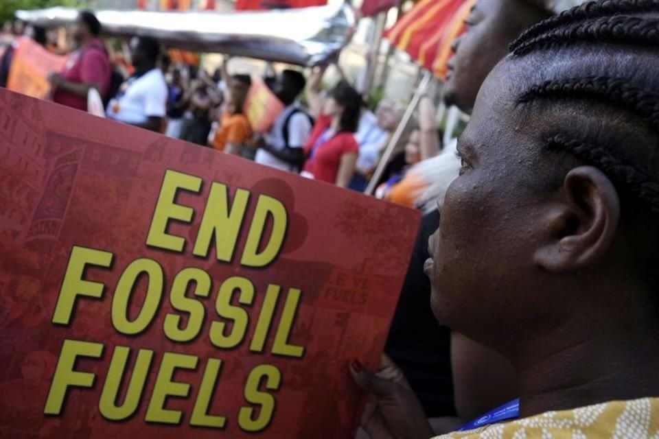 Un activista sostiene un cartel que dice 'acabar con los combustibles fósiles' en la Cumbre del Clima de la ONU COP28.