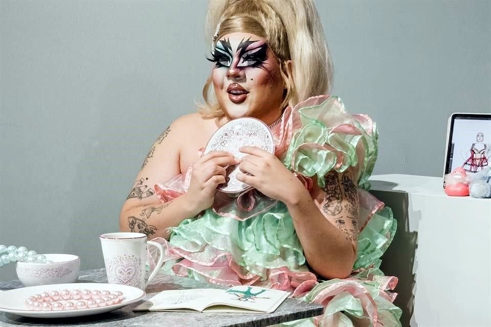 La artista drag Margaret Y Ya invita a disfrutar sin culpas ni remordimientos. Con estampados rosas sobre fondo blanco, la intérprete exhorta al carpe diem a través de la comida.