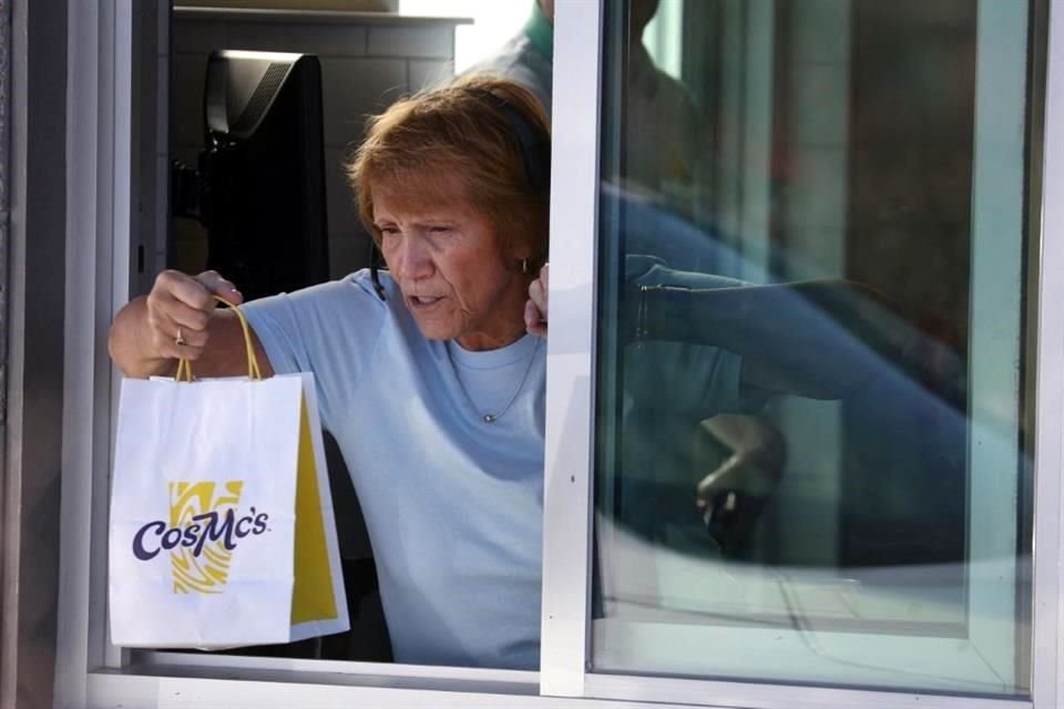 Un trabajador entrega un pedido a un cliente en CosMc's, un concepto de restaurante inaugurado recientemente por McDonald's el 11 de diciembre.