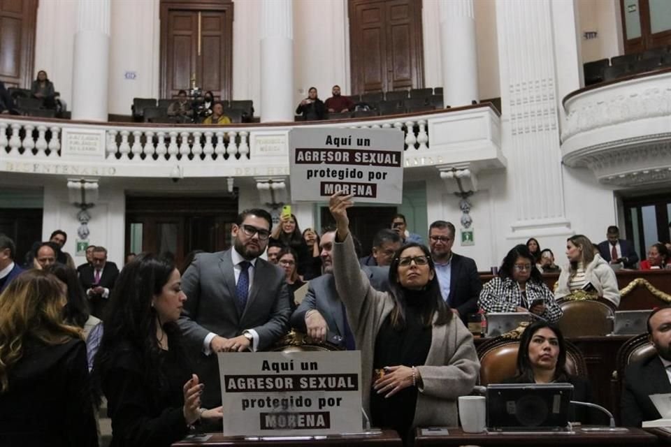 Mientras tanto, Luisa Gutiérrez alzaba cartulinas con la leyenda 'aquí un agresor sexual protegido por Morena'.