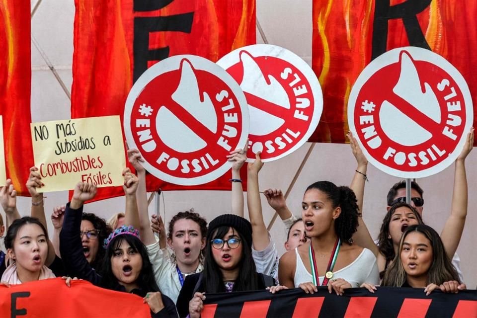 Activistas climáticos alzan pancartas contra los combustibles fósiles durante la COP28 en Dubai.