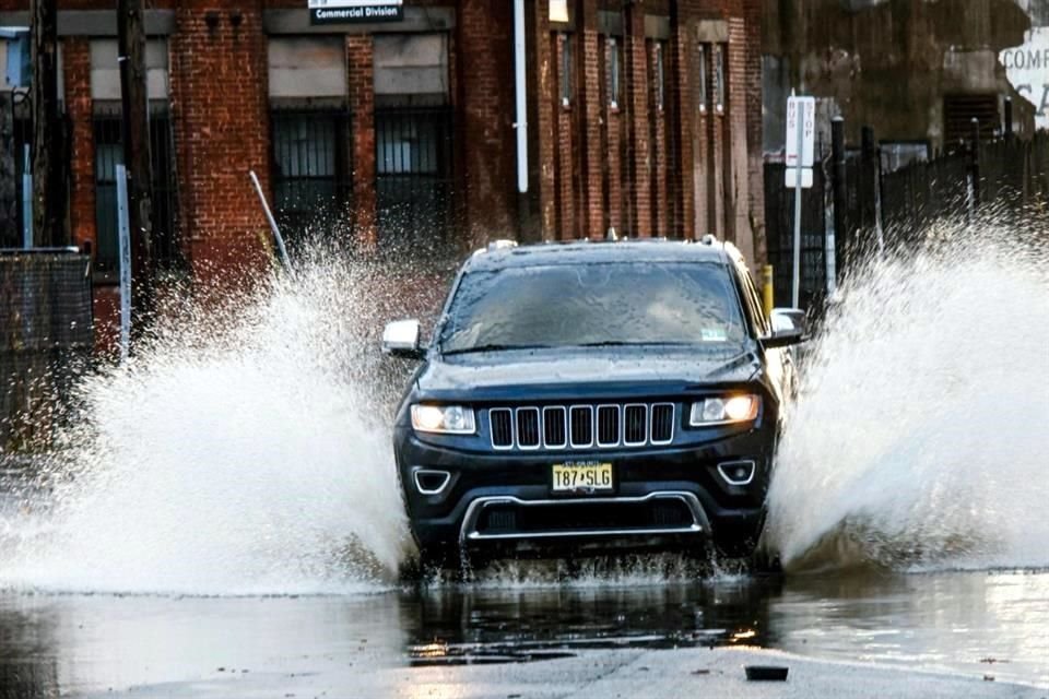 Un automóvil circula por una calle inundada después de una gran tormenta en Paterson, Nueva Jersey.