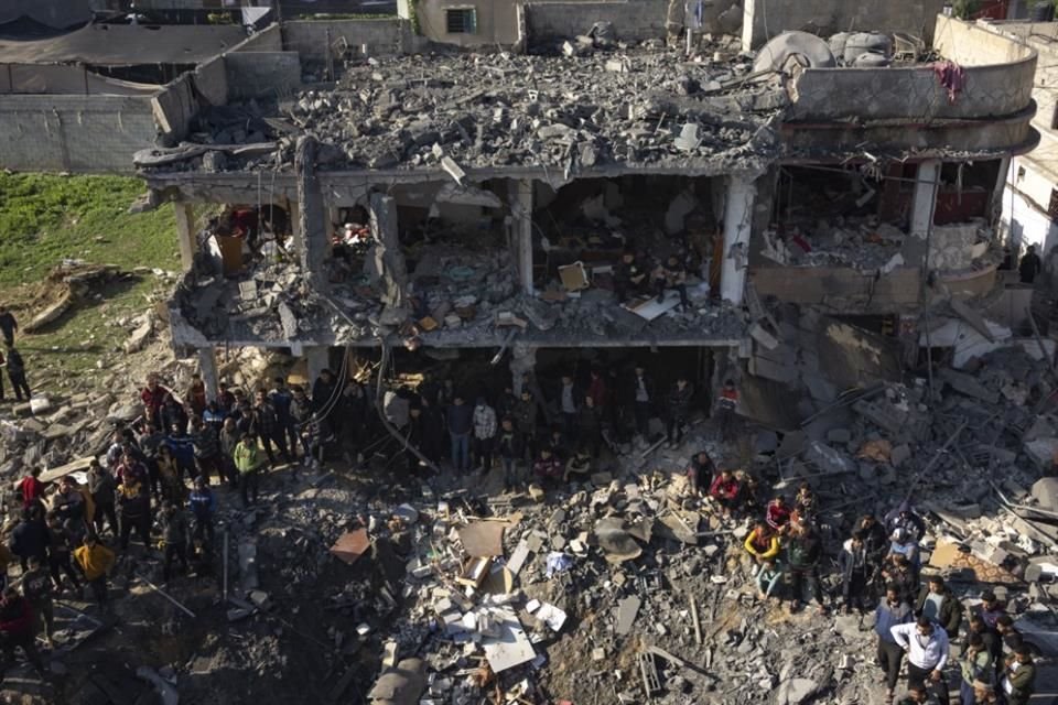 Palestinos buscan cuerpos y sobrevivientes entre los escombros de un edificio destruido durante un bombardeo.