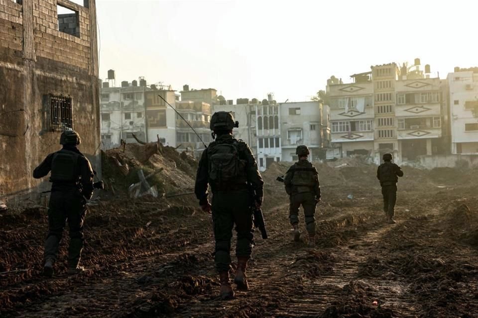 Soldados israelíes caminando junto a edificios dañados durante una operación militar en el norte de la Franja de Gaza.