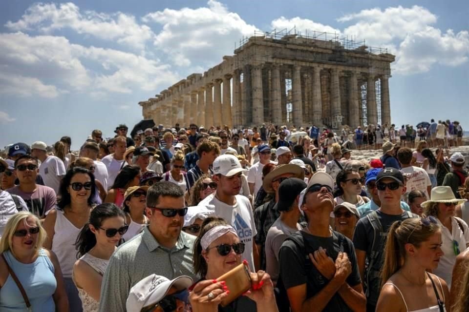 Decenas de turistas visitan el Partenón en la cima de la antigua Acrópolis de Atenas en julio pasado; a partir de abril, será posible ahorrarse las aglomeraciones.