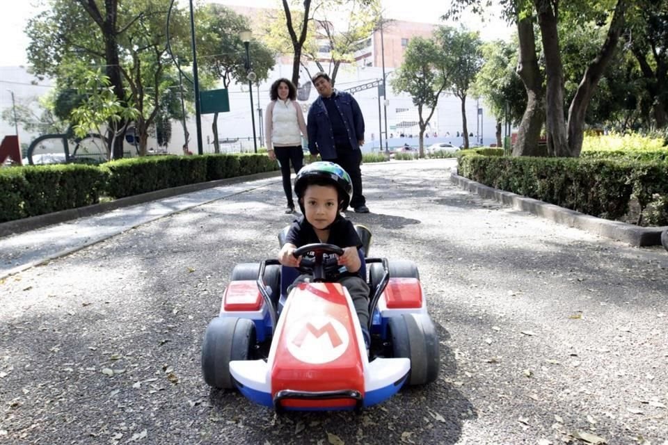 Un conductor primerizo muy bien acompañado de sus padres para no chocar en el parque.