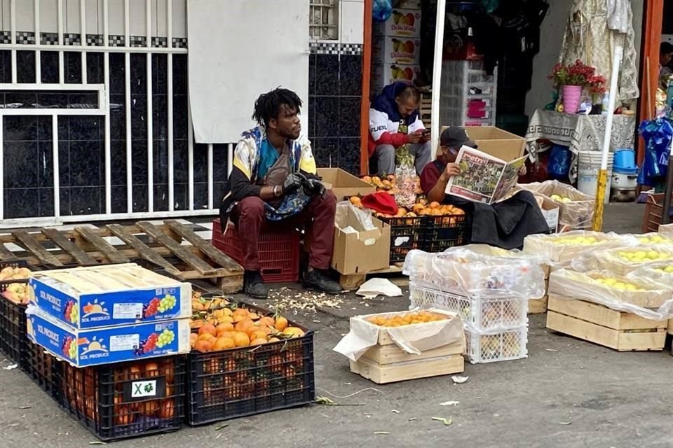 En la zona de bodegas de la Merced, migrantes trabajan en puestos callejeros.