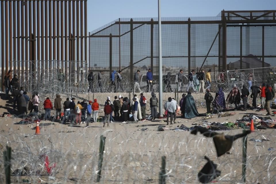 Migrantes formados después de ser detenidos por las autoridades migratorias de Estados Unidos en el muro fronterizo.