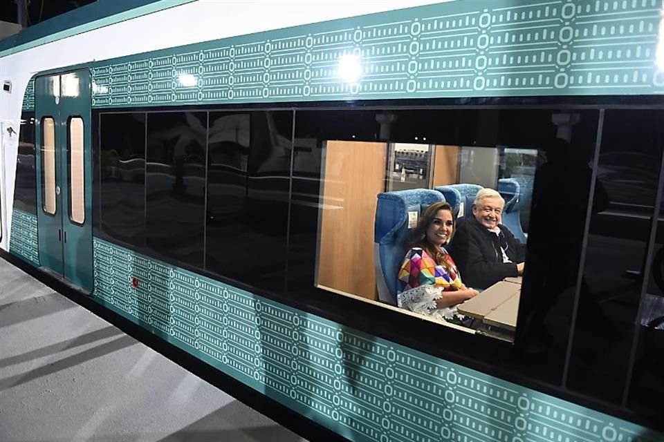 Mara Lezama (Gobernadora de QR) y el Presidente Andrés Manuel López Obrador sonríen desde el interior del Tren Maya en la estación de Cancún.