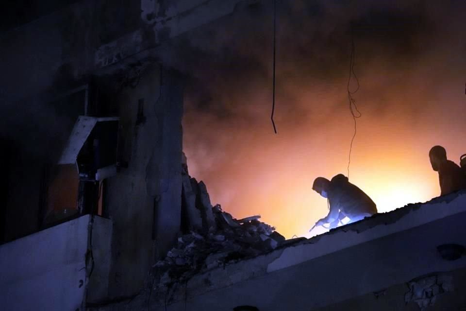 Un hombre intenta extinguir el fuego dentro de un apartamento luego de una explosión masiva en el suburbio sur de Beirut, Líbano.