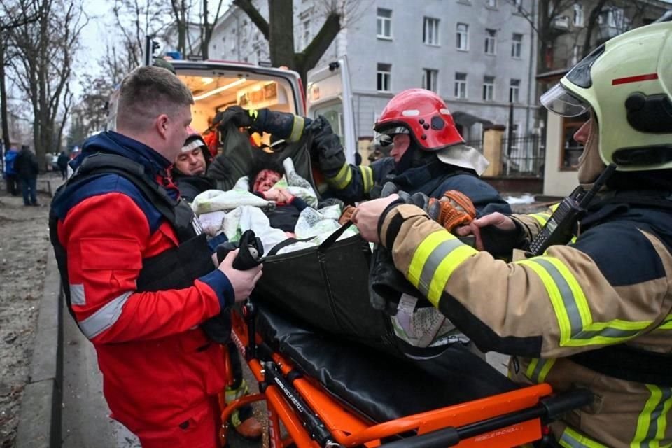 Los rescatistas ucranianos evacuan a una mujer herida de un edificio residencial dañado en el centro de Járkov después de un ataque con misiles.