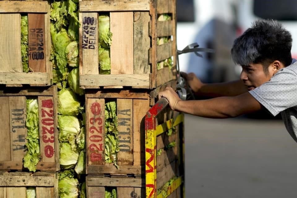 Un trabajador empuja cajas de verduras en un mercado en las afueras de Buenos Aires, Argentina.