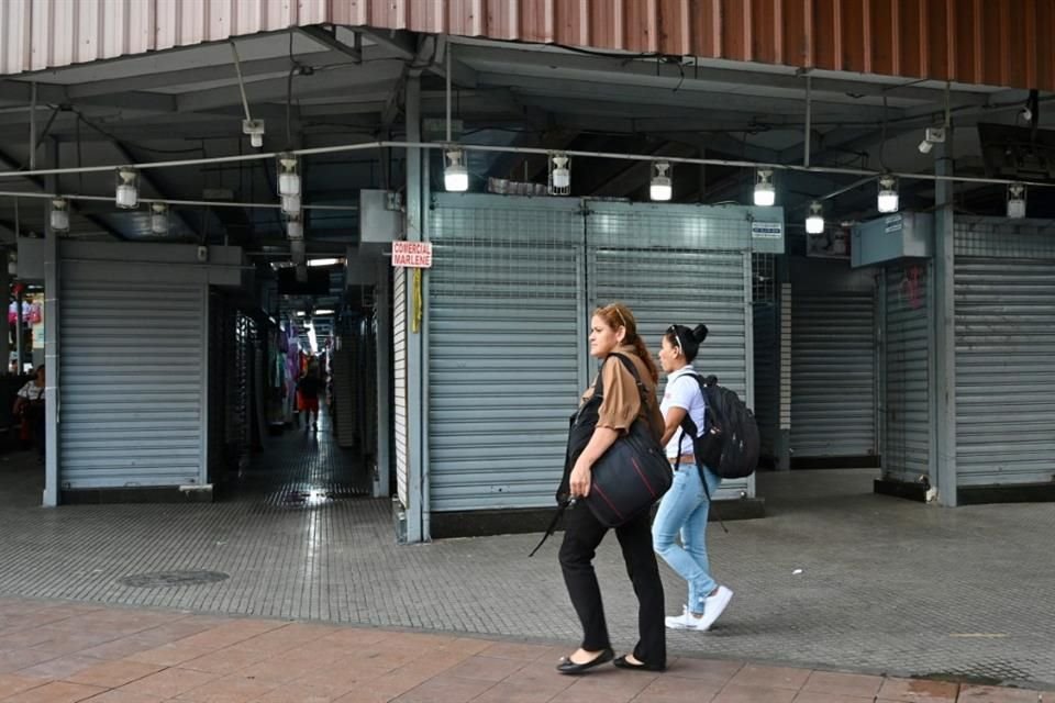 Mujeres pasan junto a negocios cerrados en el centro de Guayaquil el 11 de enero del 2024.