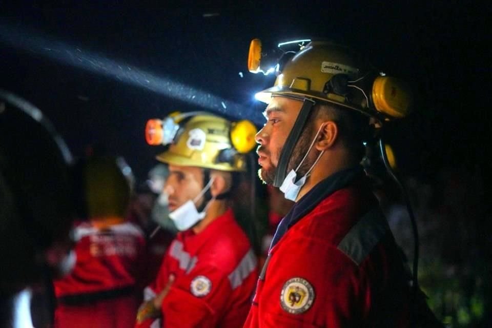 Bomberos trabajan en el sitio donde se registró un deslizamiento de tierra.