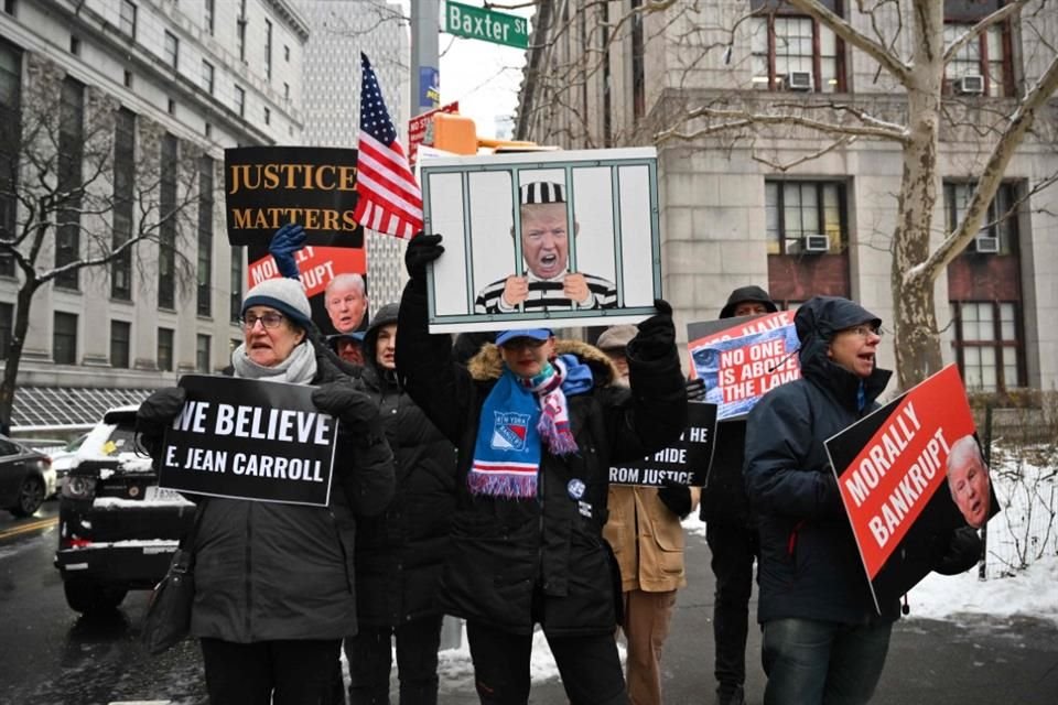 Personas sostienen carteles en apoyo a E. Jean Carroll afuera de la corte de federal de Manhattan, en Nueva York.