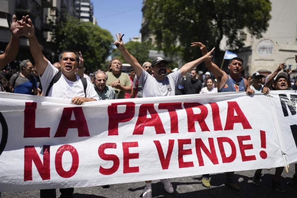 Manifestantes sostienen una lona con la leyenda 'La patria no se vende' durante una protesta en Argentina.