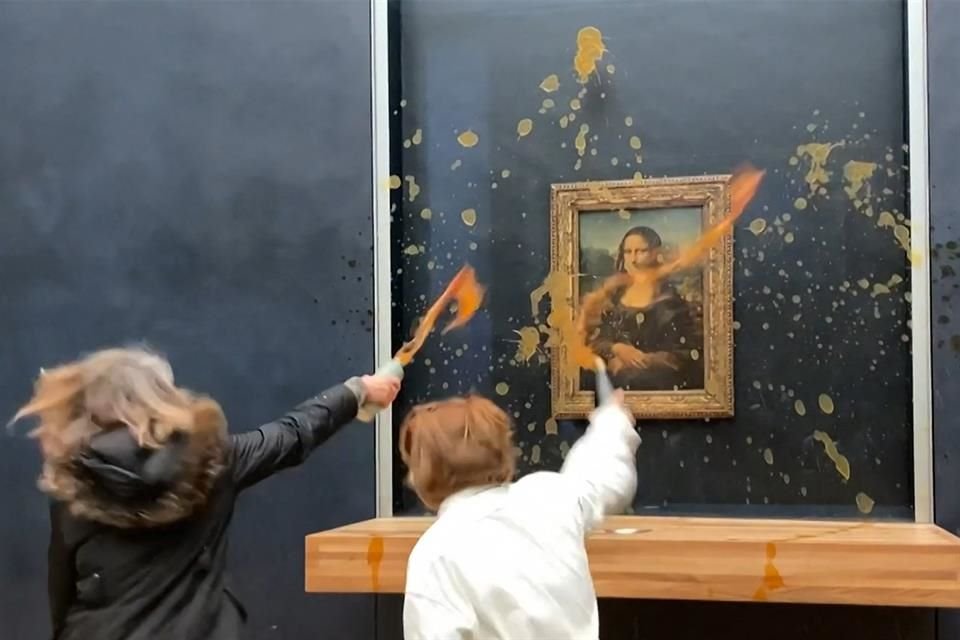 Dos activistas ambientales del colectivo denominado 'Riposte Alimentaire' (Represalias por alimentos) arrojan sopa al cuadro 'Mona Lisa' de Leonardo Da Vinci en el museo del Louvre en París.