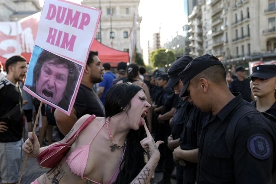 Una manifestante antigobierno se burla ante la Policía que custodia el Congreso donde los legisladores debaten una reforma impulsada por el Presidente argentino.