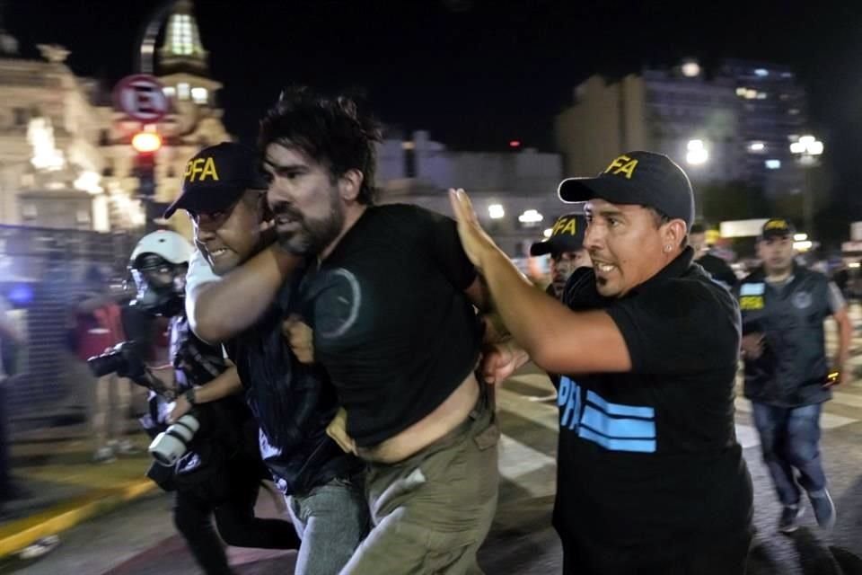 La policía detiene a un manifestante a las afueras del Congreso.