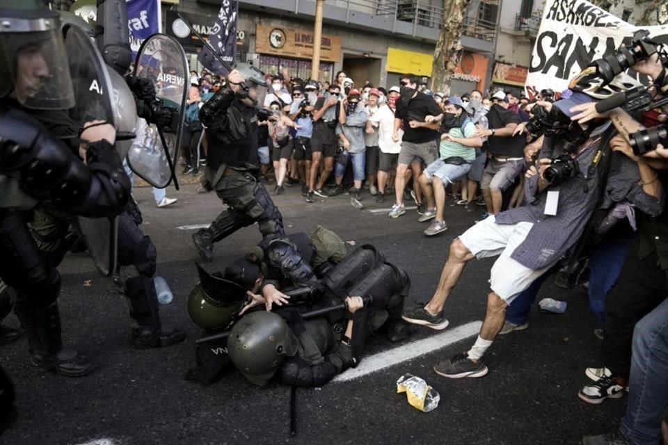 La Policía cae durante enfrentamientos con manifestantes antigubernamentales frente al Congreso donde los legisladores debaten un proyecto de ley promovido por Milei.