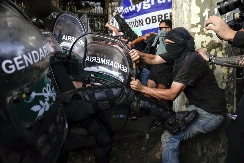 La policía y los manifestantes antigobierno forcejena a las afueras del Congreso argentino.