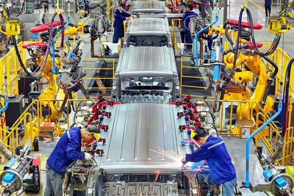 Los robots industriales colaboran con los soldadores en el taller de un fabricante de vehículos comerciales en la Zona de Desarrollo Económico y Tecnológico de Ganzhou.
