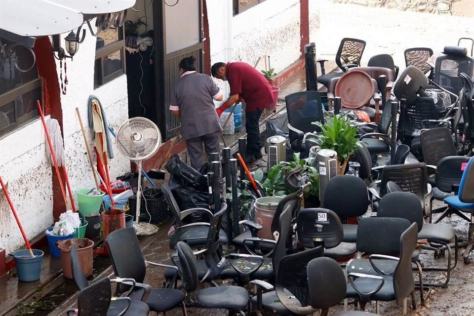 Personal de limpieza tuvo que sacar los muebles y el mobiliario de las oficinas para sacar toda el agua que inundó el sitio.