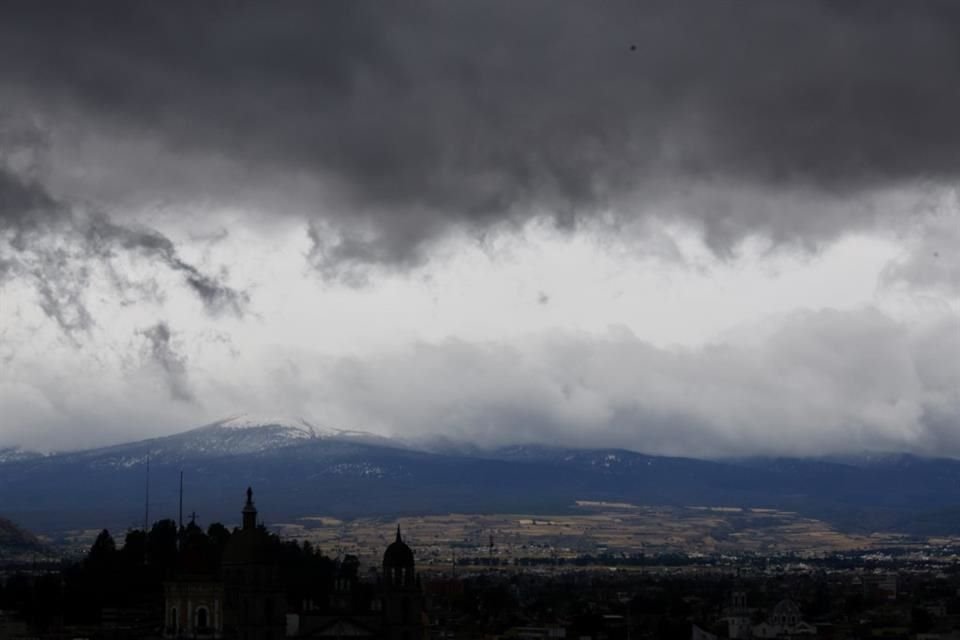 Desde la zona centro de Toluca así luce la estatua de San José de la catedral en la capital, al fondo el nevado de Toluca cubierto de nieve debido a las temperaturas.