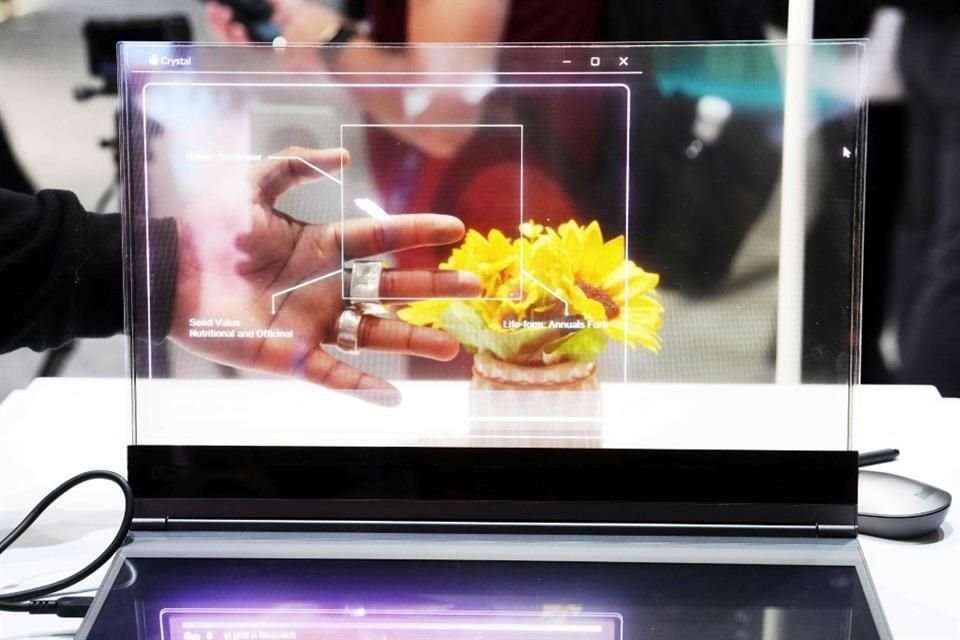 Un visitante prueba la pantalla transparente del nuevo portátil Lenovo ThinkBook.