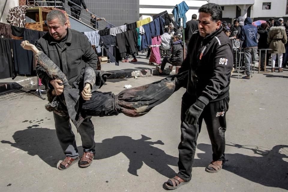 Los hombres cargan el cuerpo de un palestino muerto en un incidente temprano en la mañana cuando las fuerzas israelíes abrieron fuego contra una multitud.