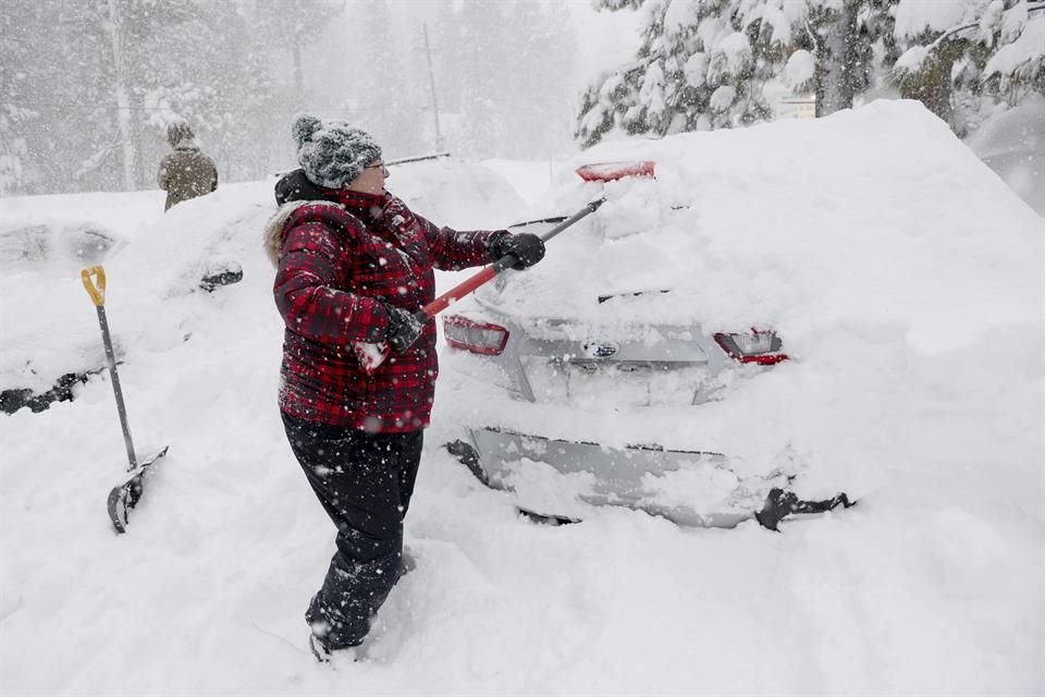 Una mujer desentierra su auto sepultado por la nieve en la ciudad de Tahoe, California, el 2 de marzo del 2024.