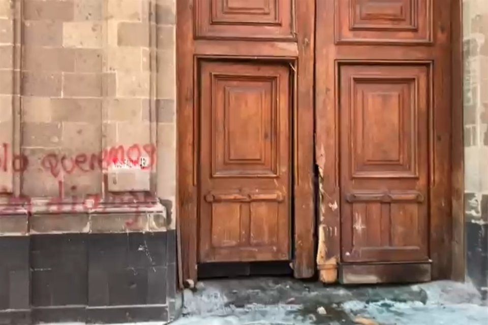 Así quedó la puerta que rompieron los normalistas.