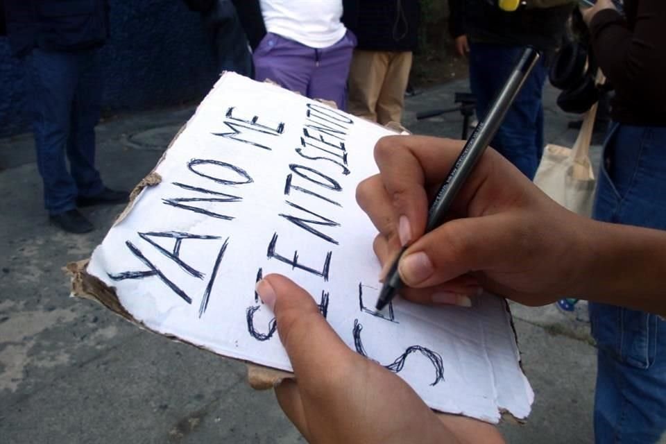 Persona escribiendo en una cartulina.