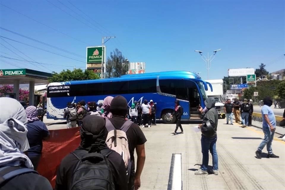 Los normalistas, en su mayoría encapuchados, llegaron el al menos cuatro autobúses a la Autopista del Sol para realizar la protesta.