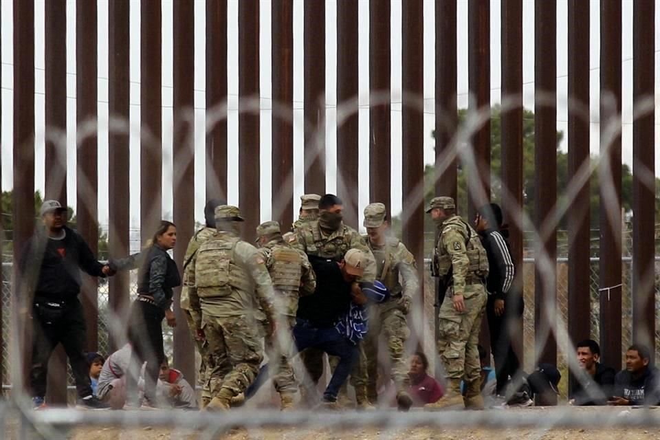 Agentes de la Guardia Nacional de Texas luchan con un migrante después de que cruzara el río Bravo para llegar al lado estadounidense.