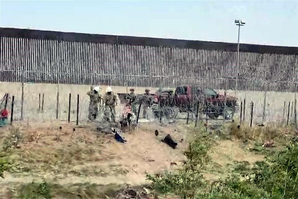 Elementos de la Guardia Nacional de Texas llevan a cabo el reforzamiento de la alambrada de púas, en medio de las polvaredas.