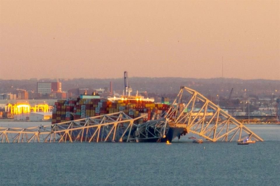 La estructura de acero del puente Francis Scott Key descansa encima de un barco portacontenedores.