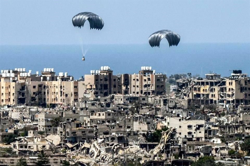 Paracaídas de ayuda humanitaria cayendo sobre territorio palestino. Imagen tomada desde la frontera sur de Israel con la Franja de Gaza.