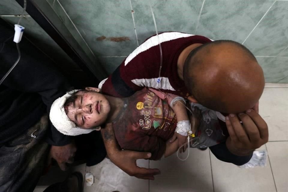 Un hombre carga a un niño herido en un bombardeo israelí en el hospital al-Najjar en Rafah, en el sur de la Franja de Gaza.