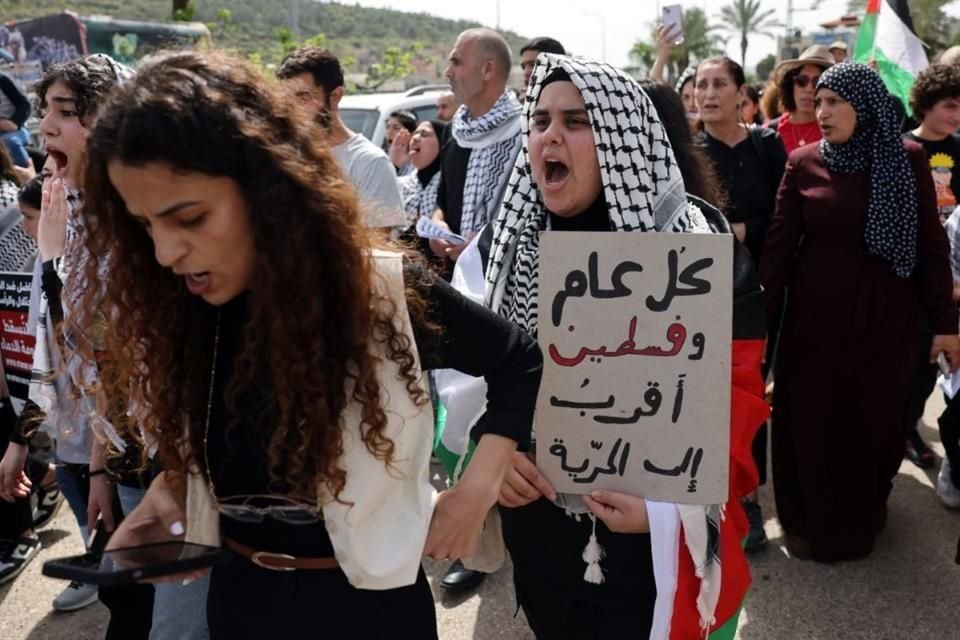 Una mujer que sostiene un cartel grita consignas durante una manifestación que conmemora el 48 aniversario del Día de la Tierra.