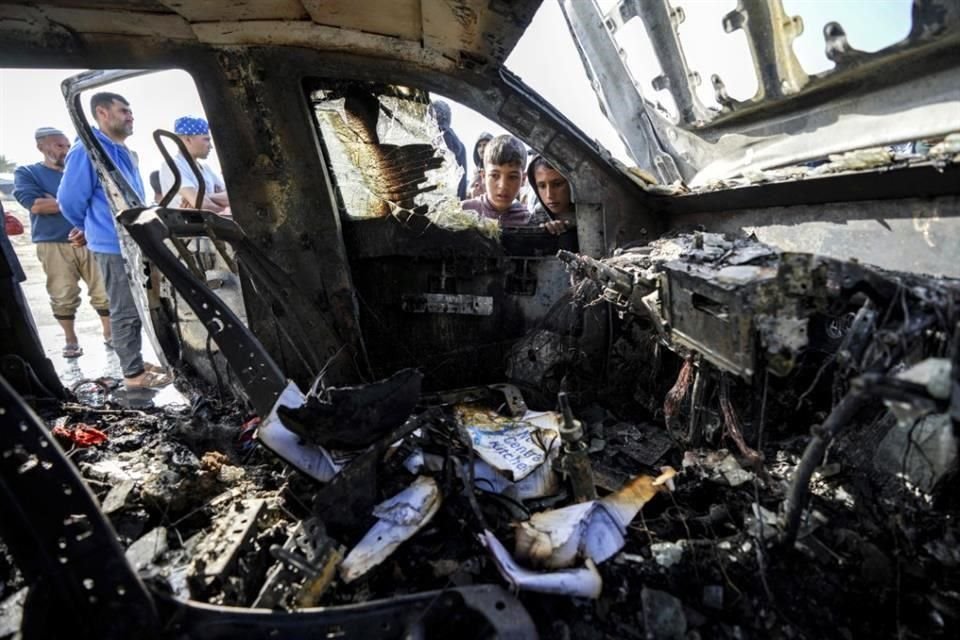 Gente inspecciona el lugar donde murieron trabajadores de World Central Kitchen en Deir al-Balah, Franja de Gaza.