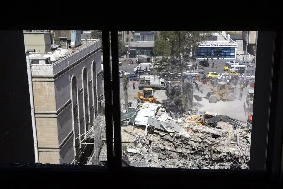 Trabajadores de rescate buscan entre los escombros de un edificio anexo a la embajada iraní un día después de un ataque aéreo en Damasco.