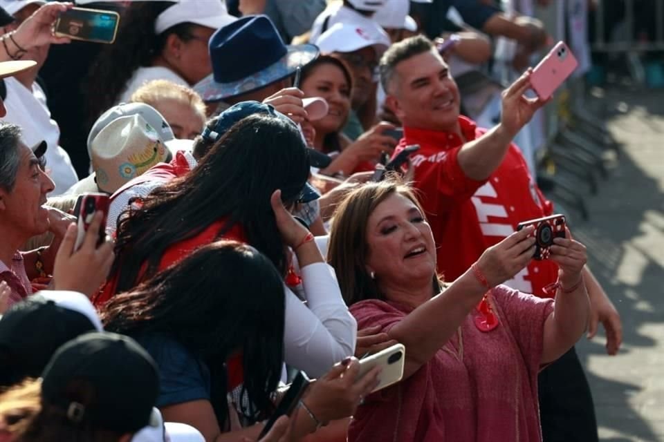 Al mismo tiempo que Xóchitl Gálvez se retrataba con presentes, detrás de ella el líder nacional del PRI, Alejandro Moreno, hacía lo mismo con otro celular.