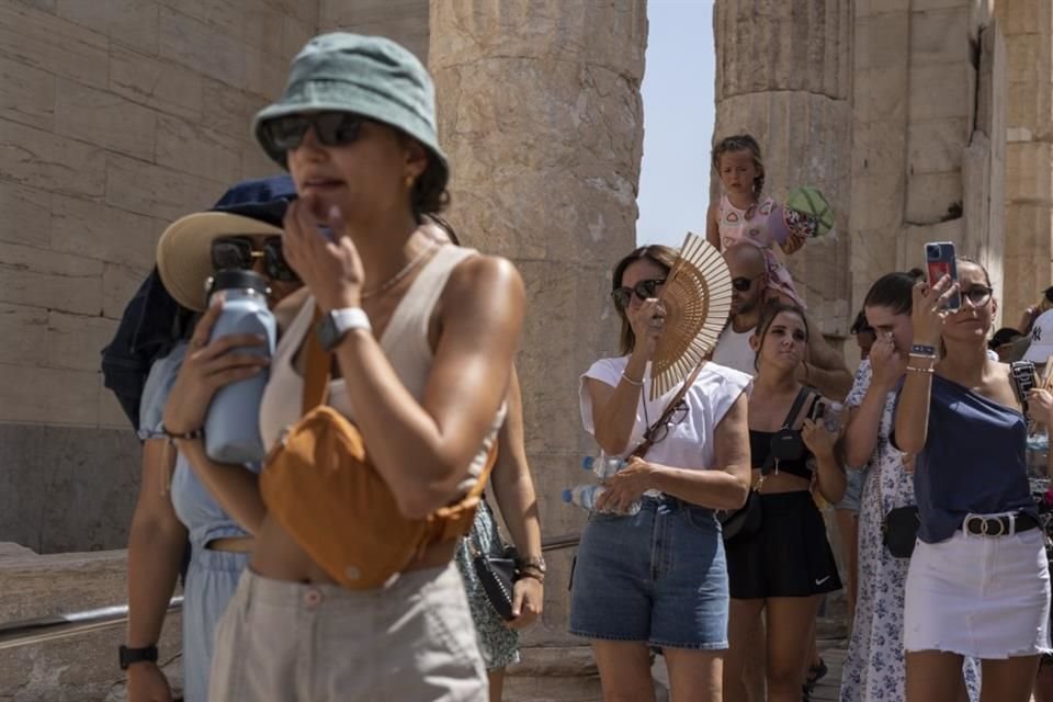 Turistas visitan la antigua colina de la Acrópolis durante una ola de calor en Atenas, Grecia, el 21 de julio de 2023.