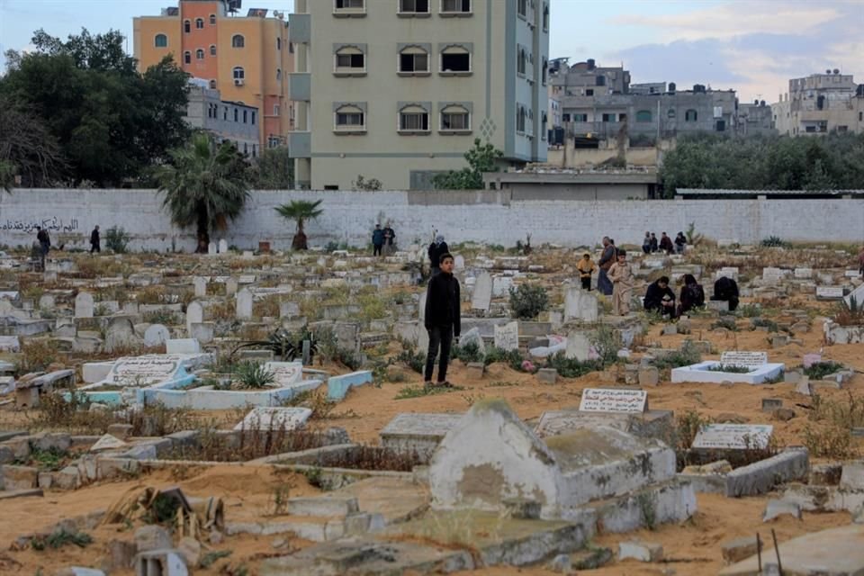 Palestinos visitan un cementerio masivo de personas fallecidas en el conflicto Israel-Hamás, en la ciudad de Rafah, en el sur de la Franja de Gaza.