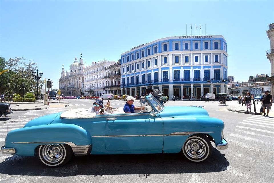 Turistas extranjeros pasean a bordo de un automóvil antiguo de la década de 1950, en La Habana, capital de Cuba, el 20 de abril de 2024.