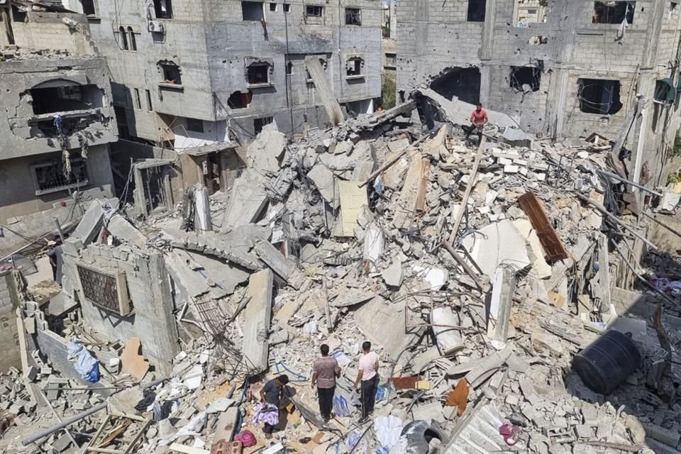 Palestinos observan los escombros tras un ataque en Rafah.
