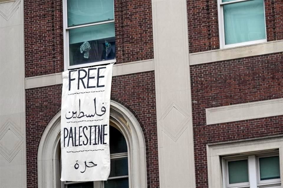 Se ve a los manifestantes a través de una ventana dentro del Hamilton Hall en el campus de la Universidad de Columbia.